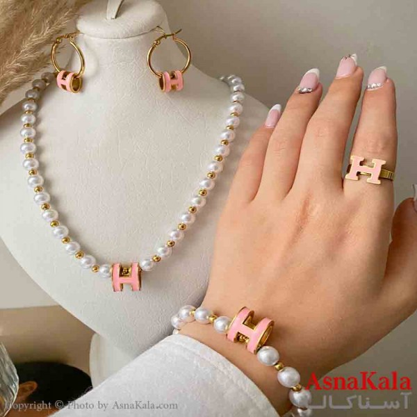 سرویس زنانه شامل گردنبند و گوشواره و دستبند و انگشتر استیل مدل مرواریدی و هرمس صورتی رنگ طلایی کد NIM14992W
