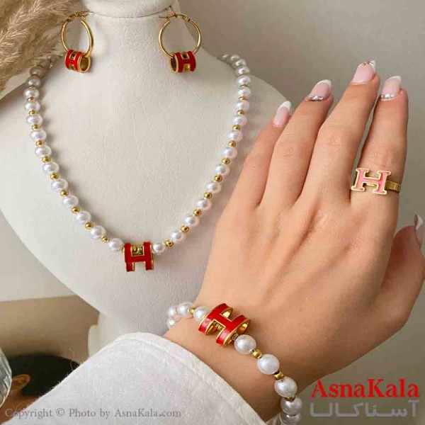 سرویس زنانه شامل گردنبند و گوشواره و دستبند و انگشتر استیل مدل مرواریدی و هرمس قرمز رنگ طلایی کد NIM14993W