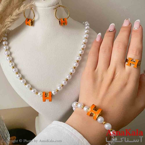 سرویس زنانه شامل گردنبند و گوشواره و دستبند و انگشتر استیل مدل مرواریدی و هرمس نارنجی رنگ طلایی کد NIM14994W