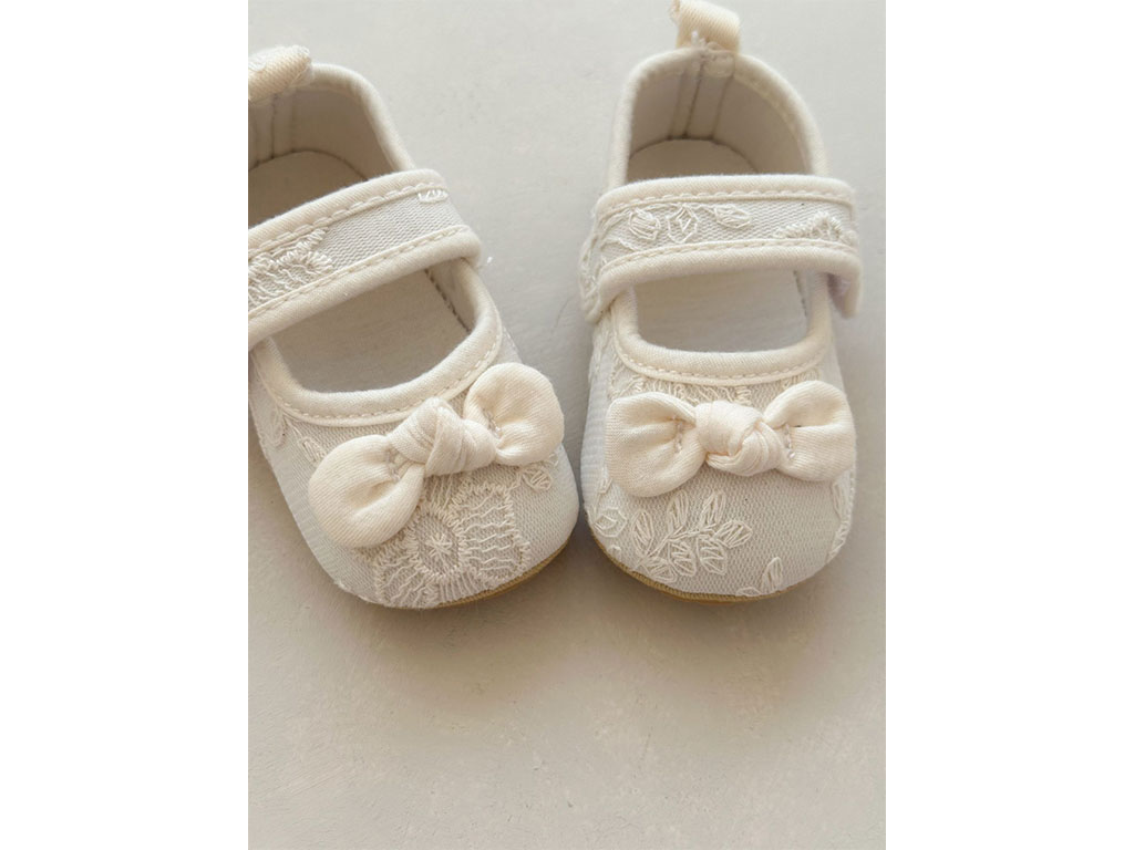 پاپوش استپ دار نوزادی رنگ شیری خامه دوزی طرح پاپیون گره