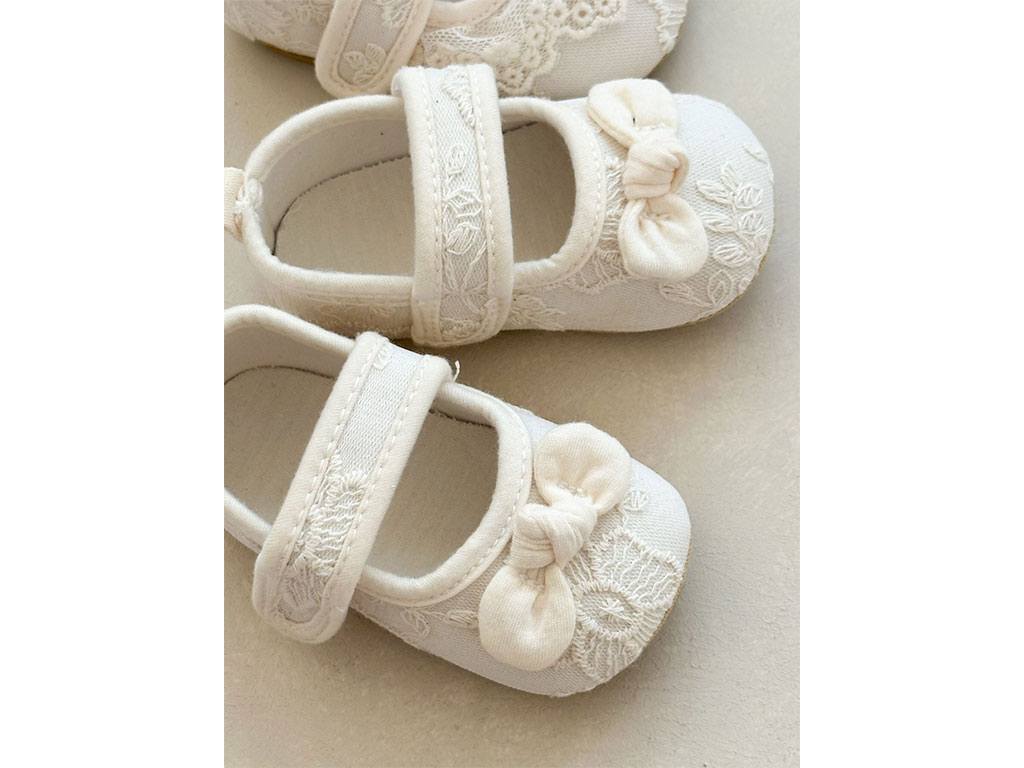 پاپوش استپ دار نوزادی رنگ شیری خامه دوزی طرح پاپیون گره