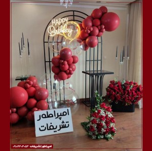 دکور بادکنک‌آرایی قرمز مات با گل‌های سرخ مصنوعی