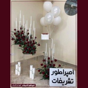 دکور بادکنک سفید مرواریدی با گل‌های رز سرخ مصنوعی و شمع‌های سفید