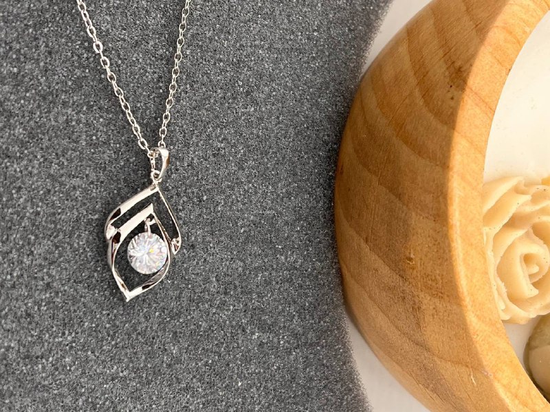 گردنبند نقره‌ای با طراحی هنری و نگین درخشان استنلس استیل