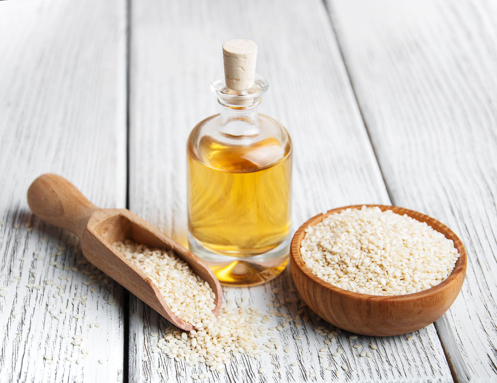 روغن کنجد در کنار دانههای کنجد