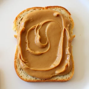 کره بادام زمینی ارگانیک خالص 400 گرمی مثه‌خودته، سرو شده روی نان تست کامل برای صبحانه سالم